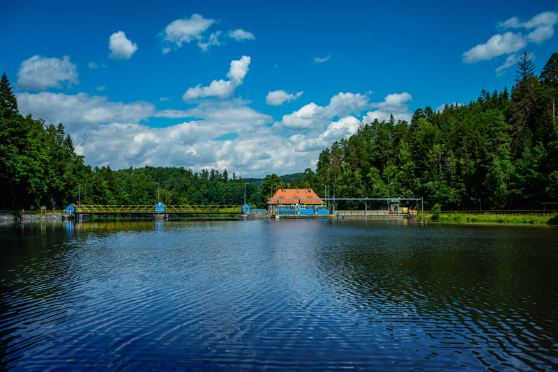 Budynek elektrowni wodnej i jaz piętrzący z oddali